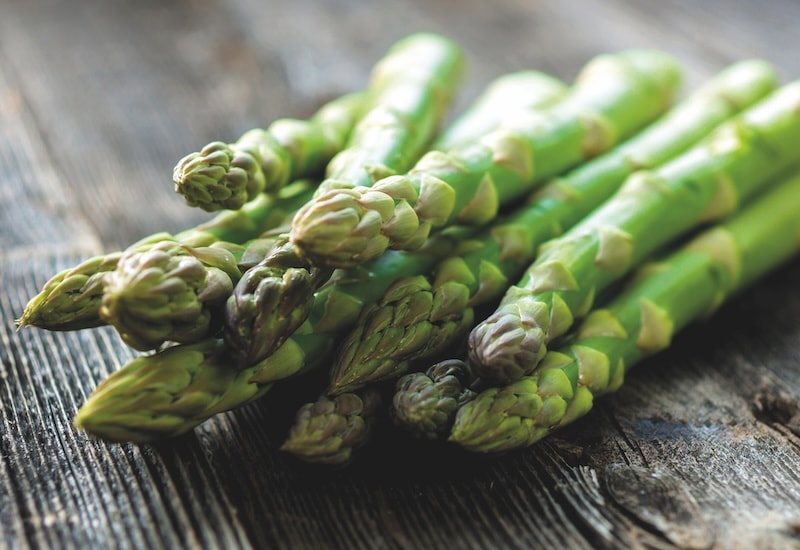 Green asparagus spears on wooden table