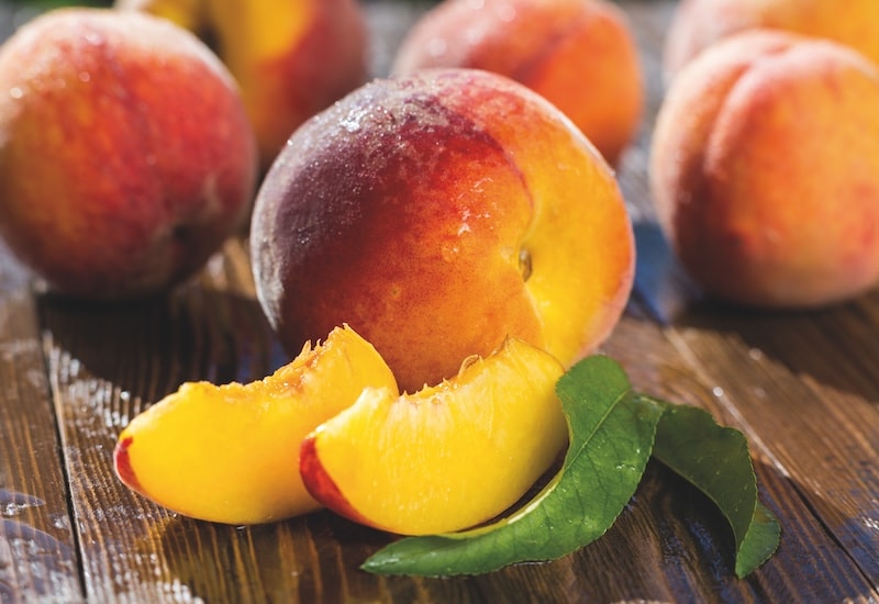 Closeup of peach fruit with two peach slices
