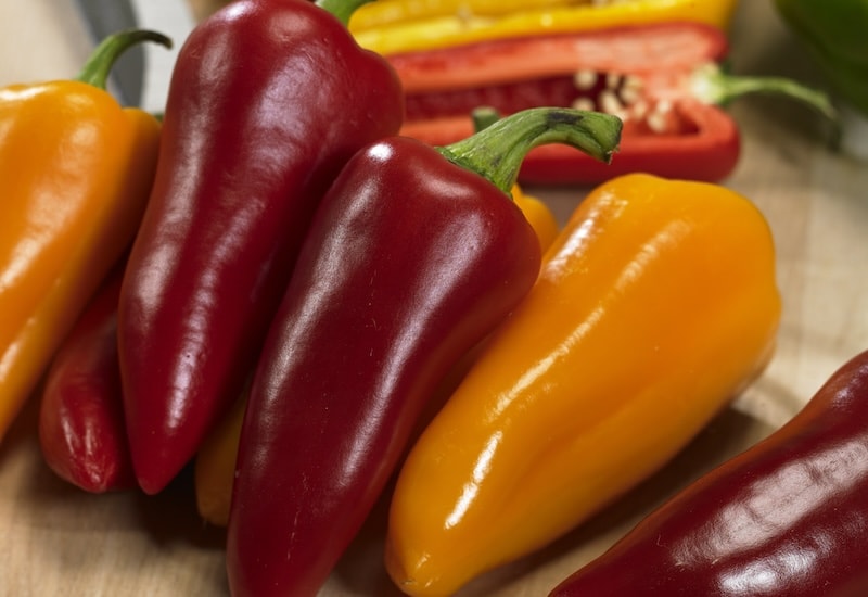 Red and orange peppers on table