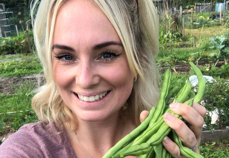 Nikki Jones, holding home grown broad beans.