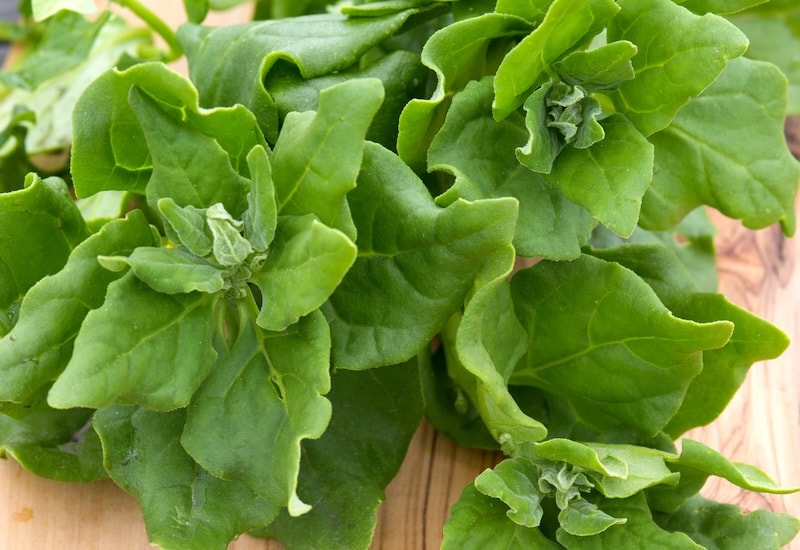 Spinach leaves against wooden table